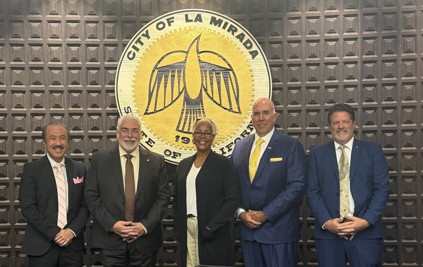 Malaika Ware with four La Mirada councilmembers in the City Council chambers, standing in front of the city seal.