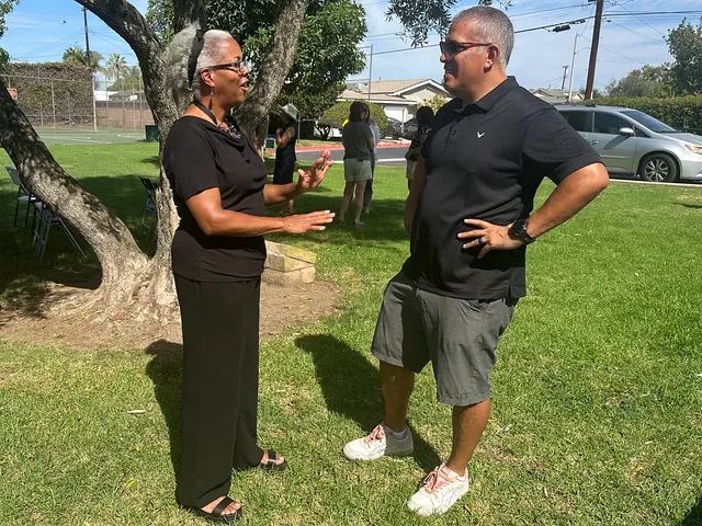 Malaika Ware talking with a neighbor at the campaign kickoff at Neff Park.